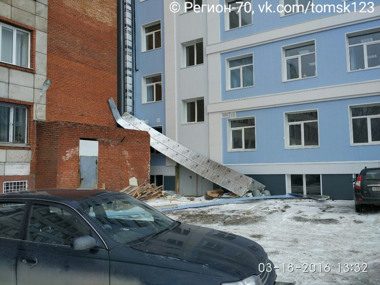 Четыре авто пострадали от падения сайдинга со стены здания в Томске
